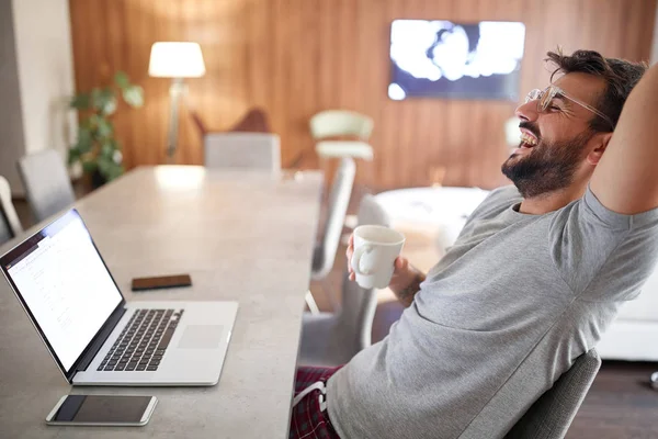 Le man dricka morgon kopp kaffe när du arbetar på laptop. — Stockfoto