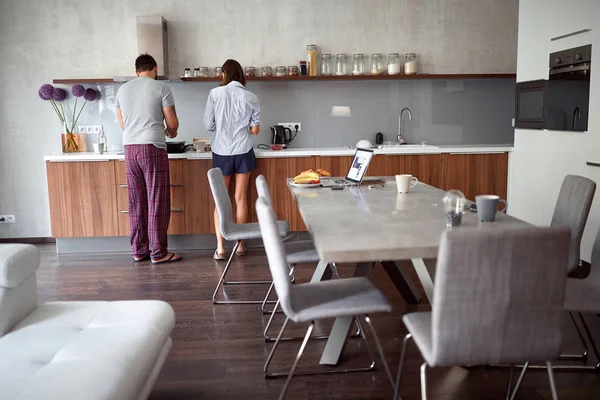 Jovem casal fazendo café da manhã na cozinha — Fotografia de Stock