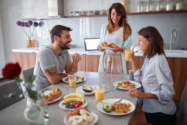 friends in pajamas breakfast in the kitchen and having fun toget