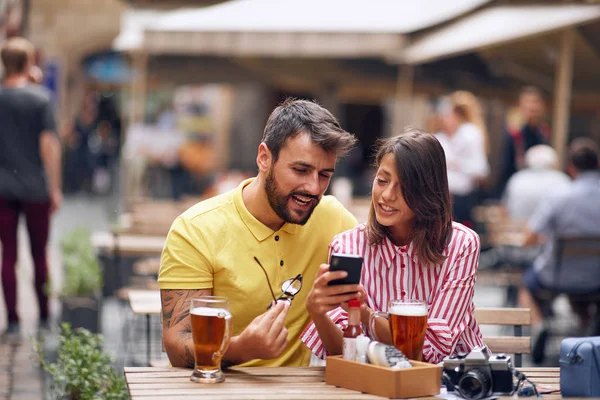 Homem e mulher de turistas verificando a localização no telefone no caffe . — Fotografia de Stock