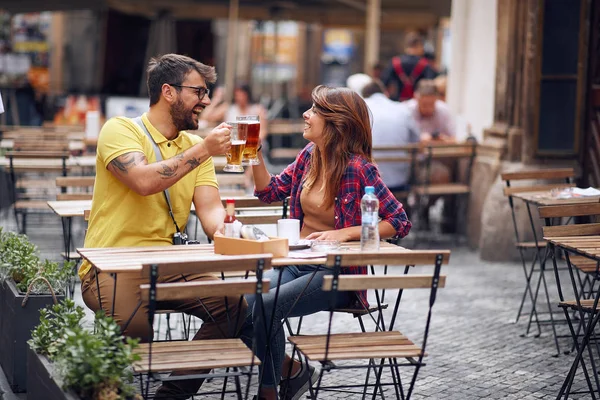 Hombre y mujer sosteniendo tazas de cerveza y animando por su amor . —  Fotos de Stock