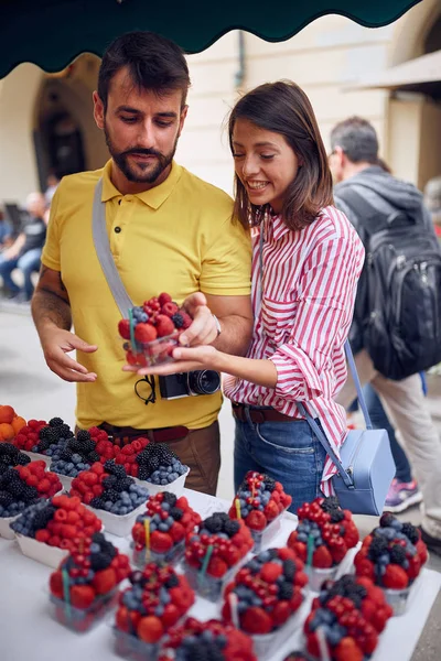 Pareja viajero comprar fruta fresca en el mercado de alimentos en la calle — Foto de Stock
