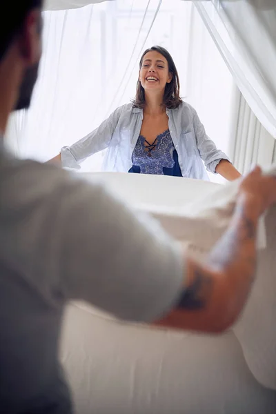 Sexy jovem casal em roupa interior fazendo a cama na parte da manhã . — Fotografia de Stock