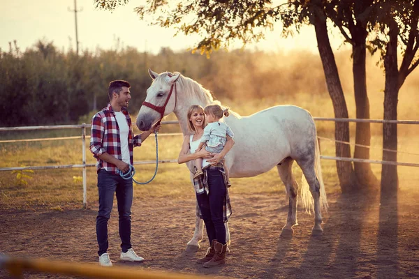 Gelukkige familie op de paardenranch. Jonge gelukkige familie met plezier een — Stockfoto