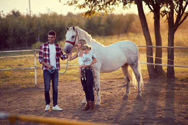 Liefdevolle familie van drie en een paard. jong gelukkig familie having fu — Stockfoto