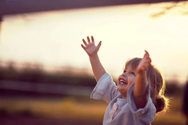 Счастливый ребенок смотрит на небо. весело на природе, закат золотой — стоковое фото