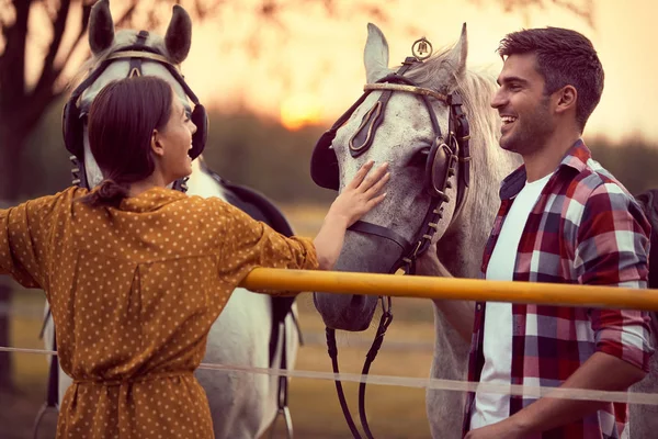 Ευτυχισμένο ζευγάρι που περνάει καλά στο ράντσο με τα άλογα. Διασκέδαση στην ύπαιθρο, — Φωτογραφία Αρχείου