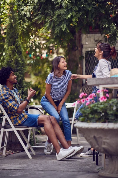 Grupo de jóvenes amigos sonrientes hablando al aire libre mientras tienen un — Foto de Stock