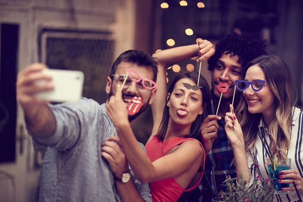 Fröhliche Gruppe von Freunden hat Spaß mit Requisiten am Stock in der Nacht — Stockfoto