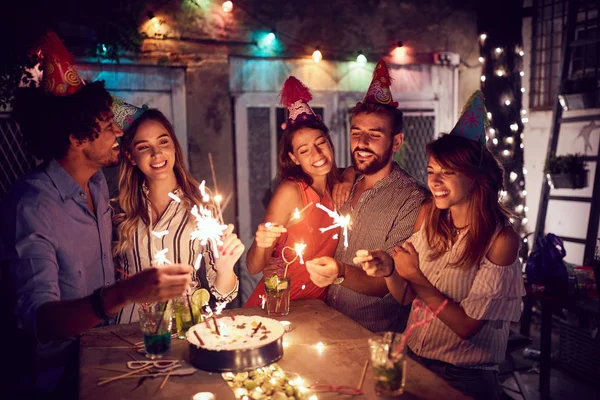 Усміхнена група молодих друзів, які проводять вечірку на день народження в підказці — стокове фото