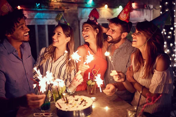 Усміхнена група молодих друзів, які проводять вечірку на день народження в підказці — стокове фото