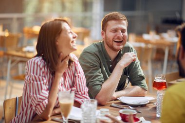 Kafedeki adam ve kadın gülüyor ve eğleniyorlar.