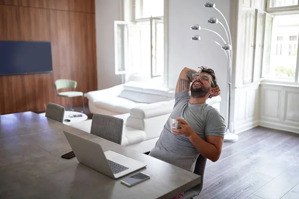 Homem bonito jovem com barba e óculos, sorrindo, sentado, inclinado para trás , — Fotografia de Stock