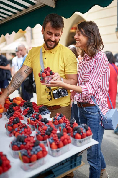 Et par som kjøper frisk frukt på markedet for mat på gata – stockfoto