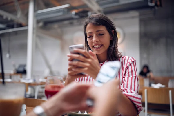 Girl  sitting at cafe and texting sms friends — Stock Photo, Image