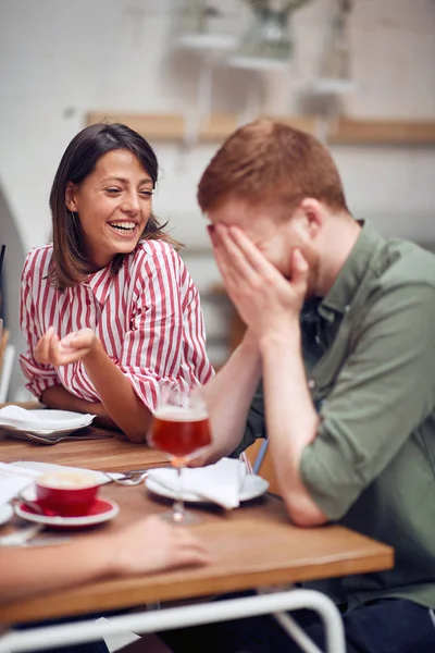 Par skrattar och njuter på ett kafé — Stockfoto