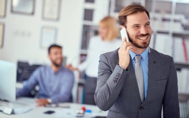 business man enjoying success at work and talking on a mobile ph