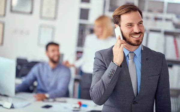 Business man enjoying success at work and talking on a mobile ph — 图库照片