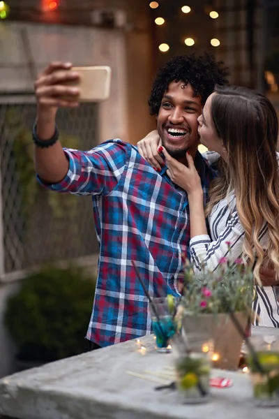 Afro-americano e masculino caucasiano feminino tomando selfie em um outd — Fotografia de Stock