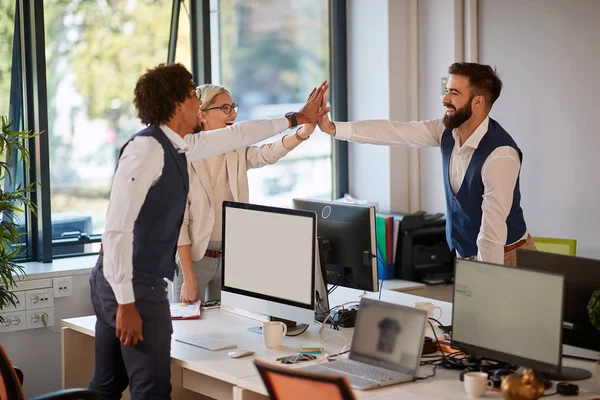 Momento de trabajo en equipo de tres colegas en la oficina de espacio abierto. te — Foto de Stock