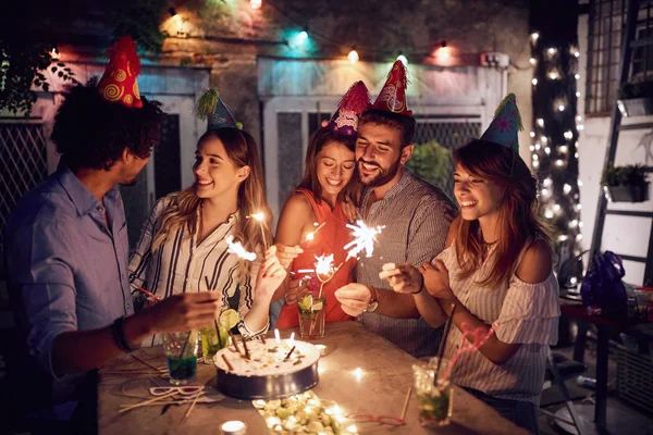 Amigos na festa de aniversário com fogos de artifício de mão em suas mãos — Fotografia de Stock