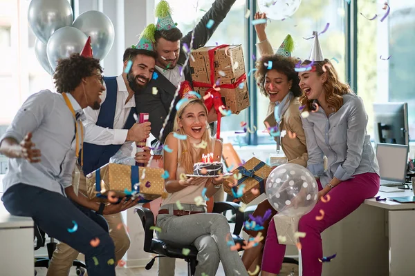 Group of colleagues surprising female colleagues with birthday c — Stockfoto