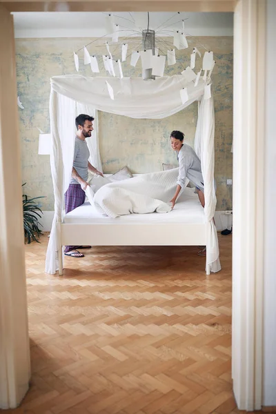 Joven Pareja Sonriendo Riendo Mientras Hacen Cama Juntos Mañana Dormitorio —  Fotos de Stock