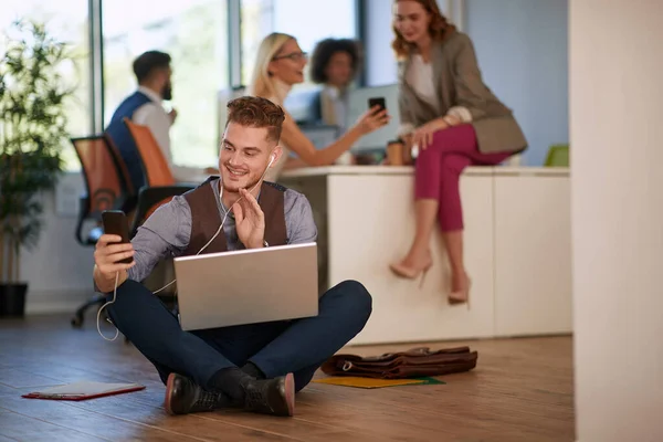 Hombre Oficina Sentado Suelo Con Portátil Usando Teléfono Celular Casual —  Fotos de Stock