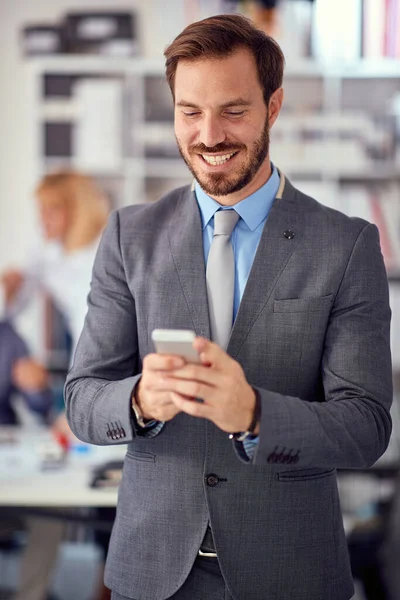 Uśmiechnięty Biznesmen Pracy Pisze Wiadomość Przez Telefon Komórkowy — Zdjęcie stockowe