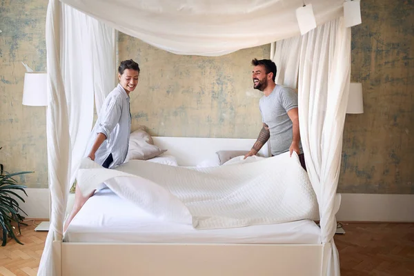 Pareja Sonriendo Riendo Mientras Hacen Cama Juntos Mañana Dormitorio Moderno —  Fotos de Stock