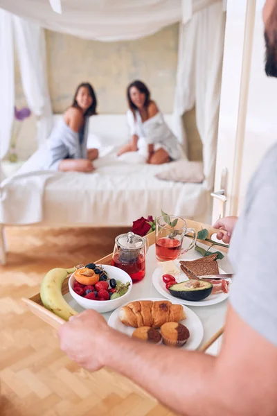2人の女性のためにベッドで朝食を世話する男 バイセクシャルで三人組の概念 — ストック写真