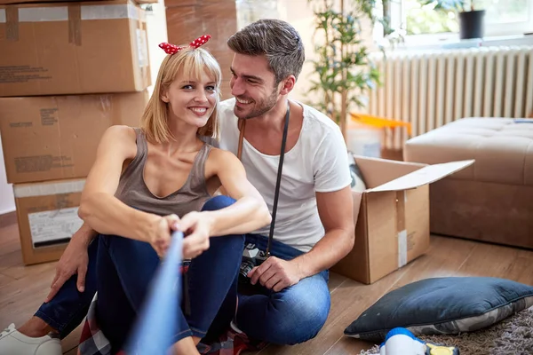 Jovem Casal Tomando Selfie Novo Apartamento Sentado Piso Com Coisas — Fotografia de Stock