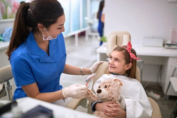 若い歯科医は 歯科椅子の子供に報酬を与える — ストック写真