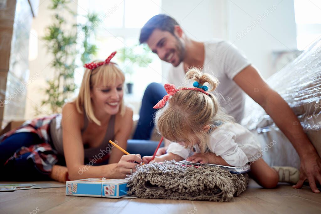 little girl playing, drawing with her parents in new apartment on the floor. family, joy, bounding, happy childhood concept