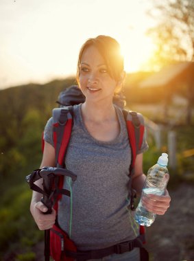 Güzel genç bir kadın şafak vakti doğa yürüyüşü yapıyor. sağlıklı, pozitif, doğa konsepti
