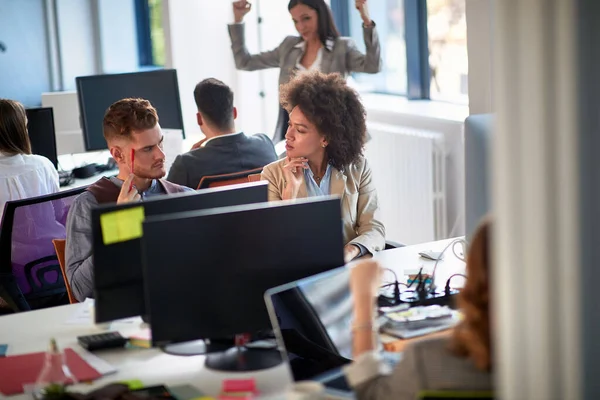 Young business people in office. Colleagues in office. Businesswoman and businessman discussing work in office. Young Man and woman  working together.