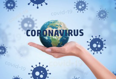 Dünya gezegeni kadın elinde, mavi Coronavirus 'un arka planında küresel hastalığın virüs örnekleri var. Covid-19 konsepti ve ev tabelasında kalın