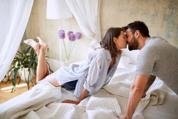 Unga Par Kysser Morgonen Medan Förbereder Sängen — Stockfoto