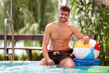 Yüzme havuzundaki neşeli genç adam