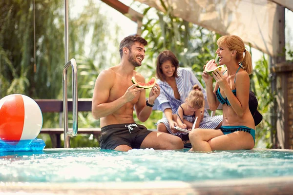 Pasangan Dengan Anak Dan Pengasuh Makan Melon Air Kolam — Stok Foto