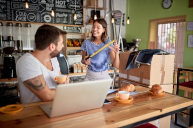 Genç çift kahvaltı yapıyor ve kahve dükkanında eğleniyor. Birazdan açacaklar. iş kurma