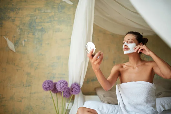 Jovem Alegre Máscara Facial Mulher Rosto Sentado Cama Olhando Para — Fotografia de Stock