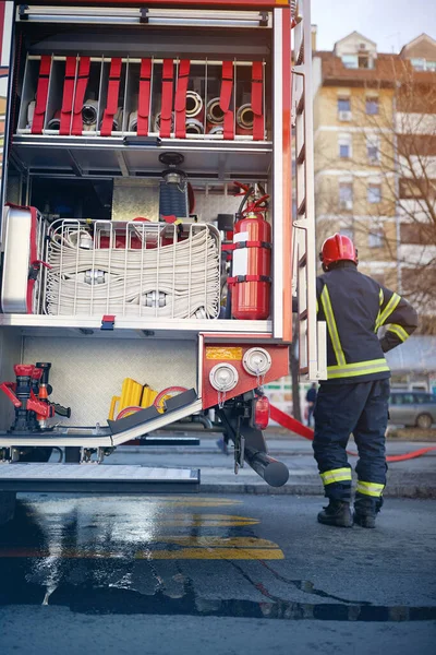 Samochód Strażacki Sprzętem Przeciwpożarowym Człowiek Strażak Mundurze Pobliżu Wozu Strażackiego — Zdjęcie stockowe