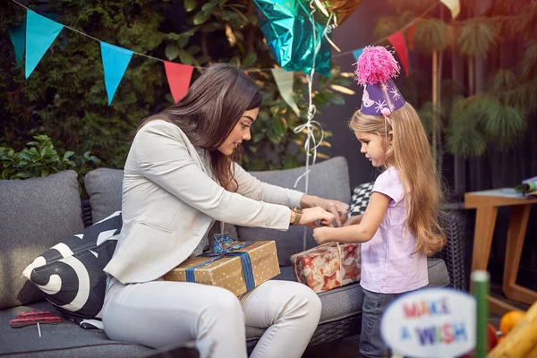 Junge Weibliche Brünette Eröffnet Geburtstagsgeschenke Mit Süßen Kleinen Mädchen Geburtstag — Stockfoto