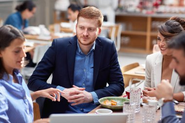 young beardy caucasian with his friends at lunch in restaurant. friends, colleagues, business partners, lunch, break  clipart