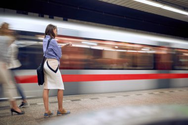 Metroda genç bir iş kadını kol saatine bakıyor. Zaman çabuk geçiyor.