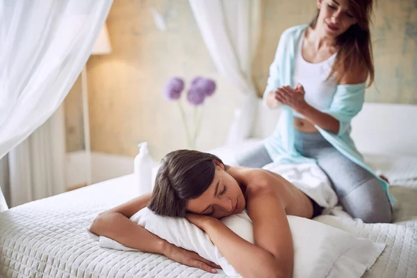 코카서스 캐노피로 침대에 여성에게 마사지를 있습니다 긴장풀기 — 스톡 사진