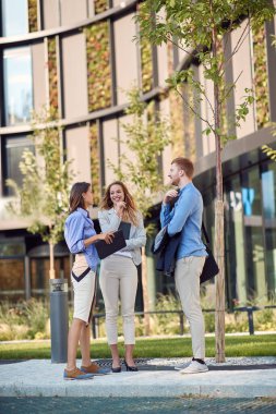 Bir binanın önünde konuşan üç beyaz iş adamından oluşan bir grup. Mola, kendiliğinden konuşma,