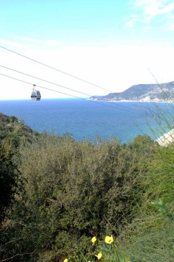 Füniküler Alanya Türkiye'deki dağlar üzerinde gökyüzünde. Modüler teleferik. Güneşli bir gün, ufukta yüksek dağlar.