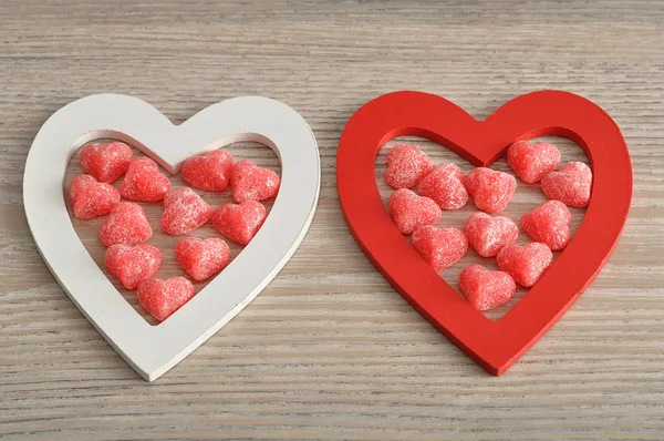 Valentine's Day. Wooden hearts filled with heart shape candy — Stock Photo, Image